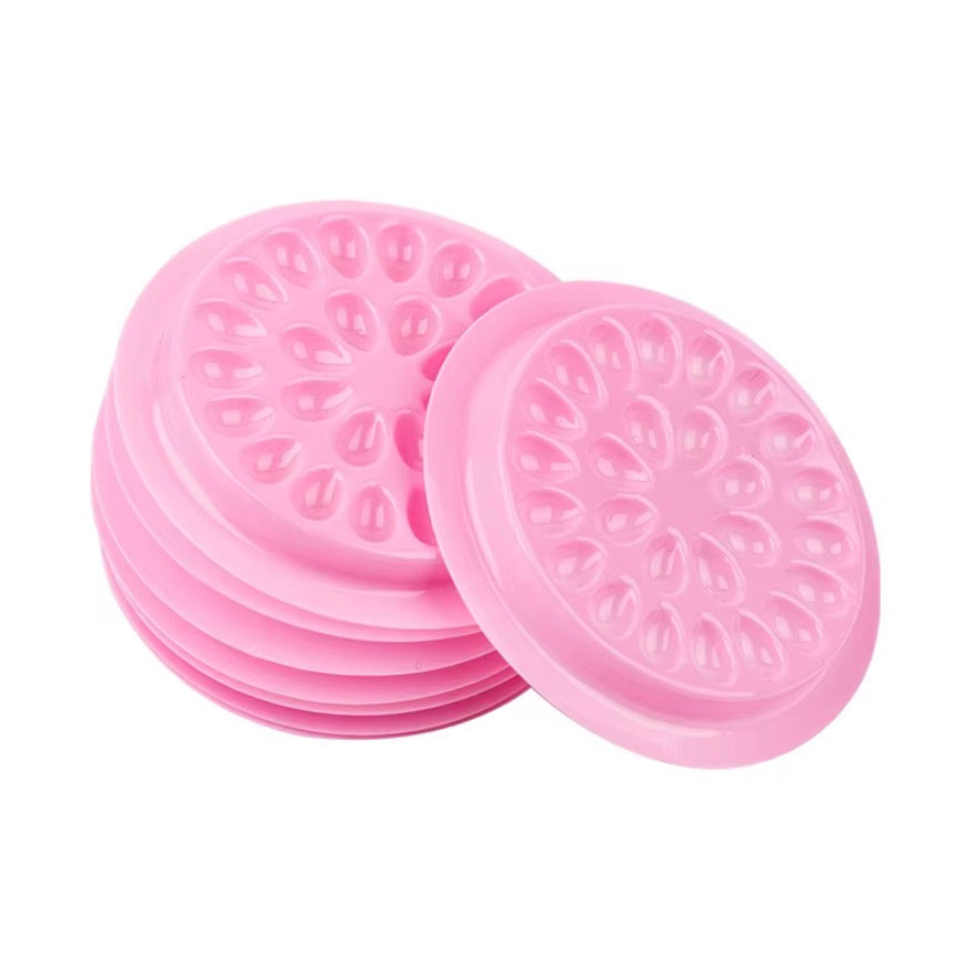 Set of pink silicone coasters with floral patterns on a white background